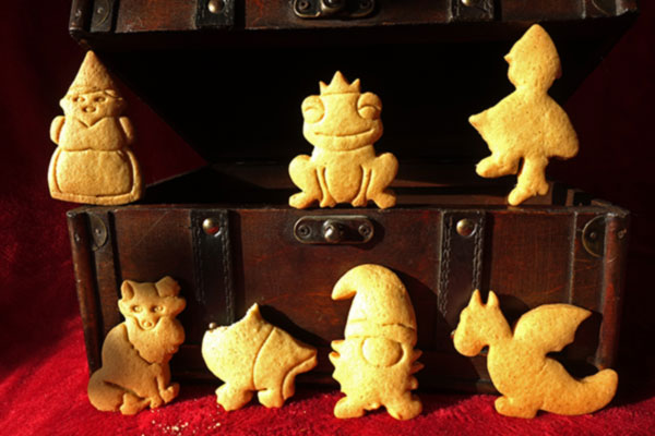 Aufnahme von Keksen mit Märchen-Motiven vor einer geöffneten alten Schatzkiste
